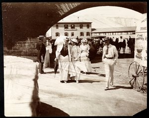 旅の写真家のカートを備えたナラガンセットの桟橋を歩いている3人の女性と男性、ロードアイランド、1891年（銀ゼラチンプリント）